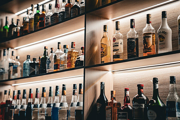 two shelves full of different types of alcohol