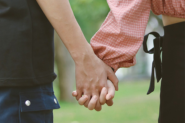 close up of two individuals holding hands