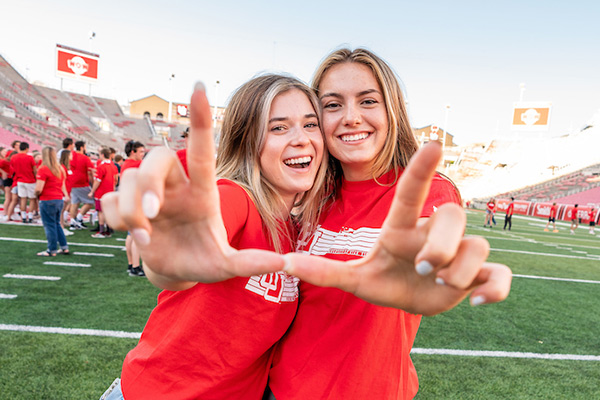 two females flashing the u while at new student orientation