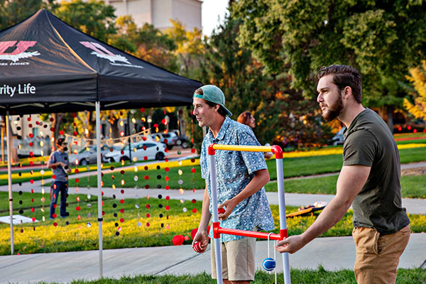 two males playing a yard game at a campus event