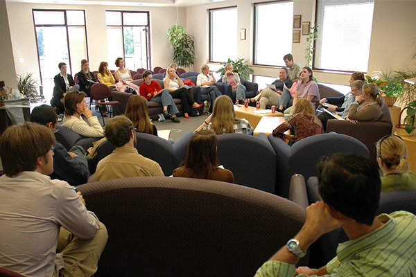 group of individuals in a support circle listening to speaker