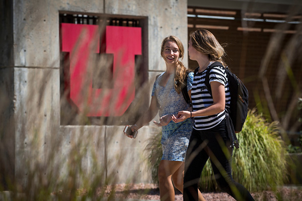 two female students walking in front of building with block u